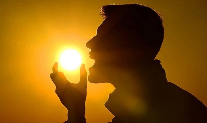 Senior Airman Michael Cossaboom, 20th Fighter Wing Public Affairs photojournalist, pretends to eat the sun during a sunrise in Asheville N.C., April 18, 2016. Finding ways to enjoy the workday keeps morale high for Airmen and their counterparts. (U.S. Air Force photo by Senior Airman Jensen Stidham)