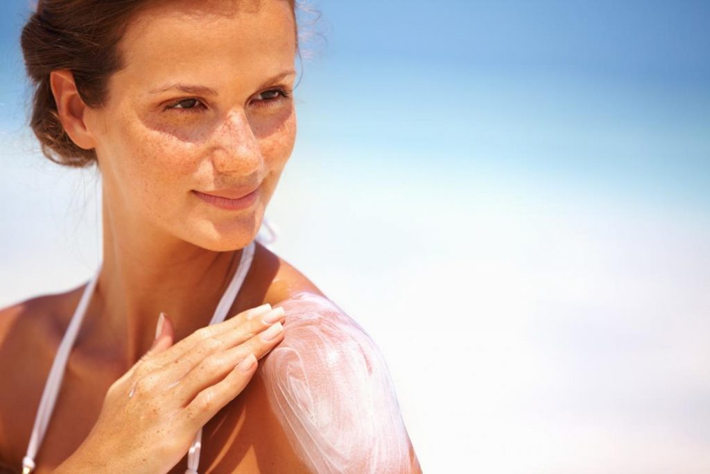 woman-in-sun-applying-sunscreen-lotion-to-her-skin